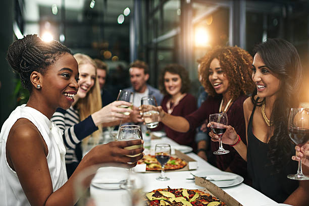 Group of friends enjoying a meal together with drinks at a restaurant.